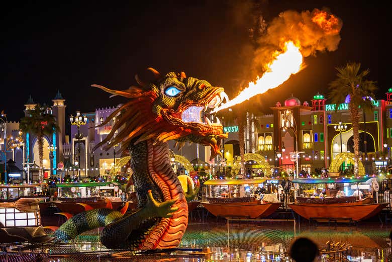 Un dragón echando fuego por la noche en Global Village